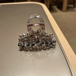 Close-up of hair claw clip with dark multifaceted beads and durable metal spring