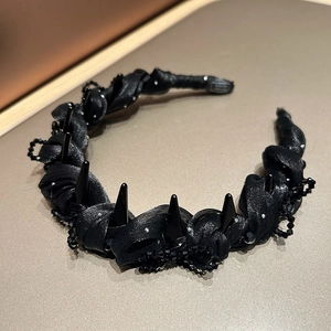 Detail of black satin headband featuring punk studs and sparkling crystal beads
