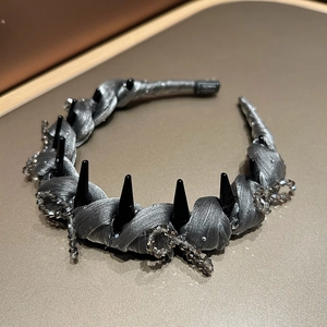 Detail of gothic silver silk headband featuring black punk spikes and crystal beads