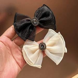 Detailed close-up of organza bow hair clips with retro rhinestones and crystals