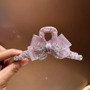 Elegant purple crystal bow hair claw clip with rhinestones for a sophisticated hairstyle