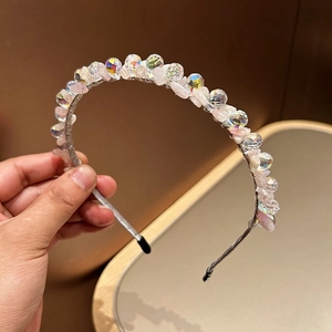 Detail of handmade headband with pink stones and sparkling crystal beads on silk band