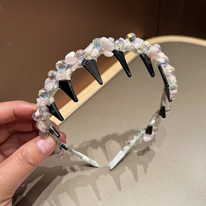 Detail of pink crystal stones and faceted beads on a headband with non-slip hair teeth