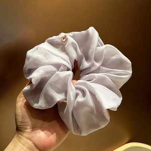 Close-up of a light purple organza scrunchie with delicate floral embroidery details