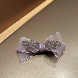 Detail showing the lavender tulle bow and shimmering crystal beadwork on the hair claw
