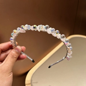 Close-up of pink crystal stone beads and iridescent crystals on a silver headband base