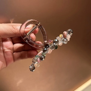 Détail des perles colorées sur une pince à cheveux en résine marron translucide