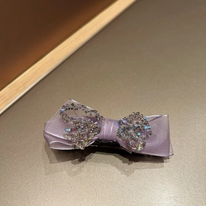 Detailed view of the sparkling crystal accents on the purple ribbon bow hair claw clip
