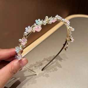 Delicate gold headband with pastel flowers and pearls for an elegant hair accessory