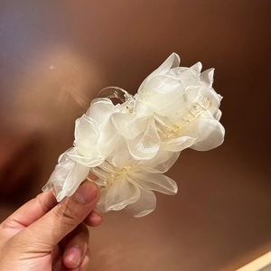 Vista dettagliata dei petali di organza bianca a più strati su questo fermaglio a fiori