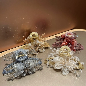 Vista dettagliata delle pinze per capelli a fiore in organza fatte a mano con cristalli e perle