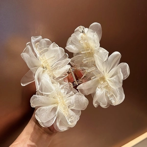 Dettaglio della grande molletta per capelli con fiori di organza color crema e petali