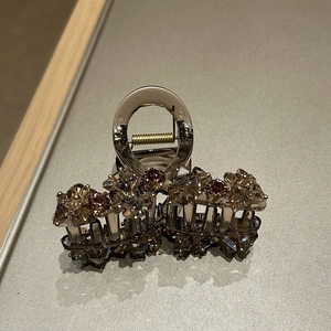 Détail de la pince à cheveux élégante avec cristaux bruns et ressort doré