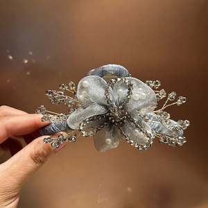 Dettaglio molletta per capelli a fiore in organza grigia con cristalli e perle
