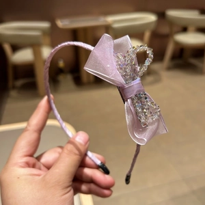 Detail of pink satin headband with organza bow and colorful crystal beads