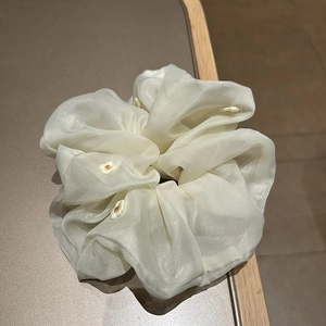 Elegant off-white organza hair scrunchie with delicate floral embroidery and glossy texture