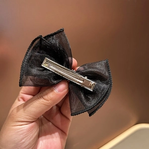 Detail of the multi-layered black organza bow hair clip with a silver metal alligator base