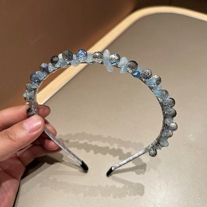 Detailed view of blue crystal beads and silver ribbon wrap on the handmade headband