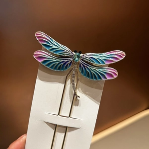 Dettaglio forcina a libellula con ali in smalto blu e corpo scintillante di zirconi