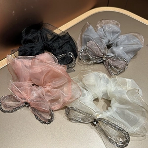 Detailed view of organza lace scrunchies with crystal bows in four elegant colors