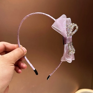 Detailed macro of a purple headband featuring a mesh bow with colorful sequins and beads