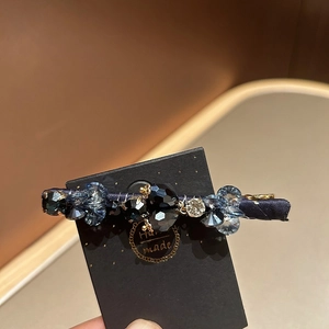 Detail of handmade crystal hair clip with blue beads and silver rhinestones