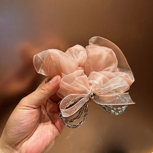 Detail of pink organza hair scrunchie with crystal bow and transparent bead strings