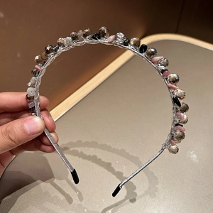 Close-up of handmade beaded headband with grey glass crystals and pink mineral stones