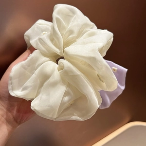 Detailed view of white and purple organza scrunchies with delicate floral embroidery