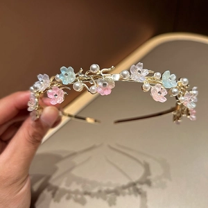 Detailed close-up of floral pearl headband with gold base and pastel resin flowers
