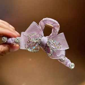 Detail of light purple satin bow hair claw clip with sparkling crystal embellishments