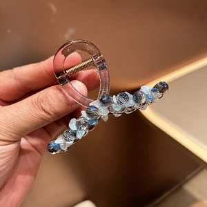 Détail de la pince à cheveux avec perles de cristal bleu et ressort en métal doré brillant