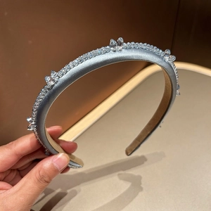 Close-up of light blue silk headband with intricate crystal beadwork and gemstones