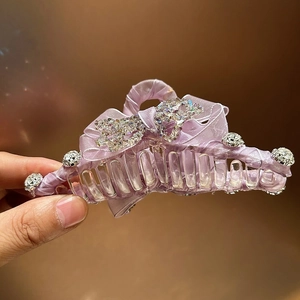 Detail showing elegant purple satin bow hair claw clip with shimmering crystal rhinestones