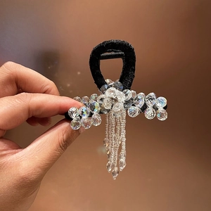 Detail of luxury beaded tassel hair claw clip with clear crystals and elegant floral design