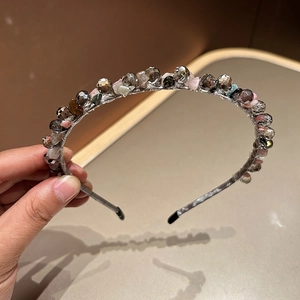 Detail of handcrafted beaded headband featuring gray crystal beads and colorful gemstones