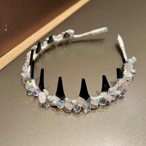 Detail of crystal beads and pink raw stones woven on a satin fabric headband