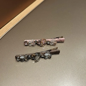 Close-up of pink and brown silk wrapped hair clips with crystal and rhinestone details