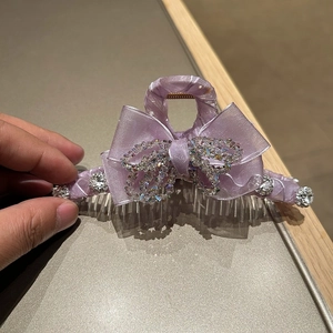 Detailed view of luxury purple satin bow hair claw clip with sparkling crystal rhinestone accents