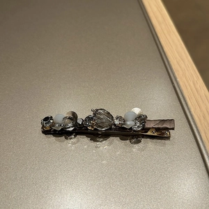 Close-up of handmade crystal hair clip with satin ribbon and sparkling rhinestones