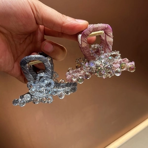 Gros plan de pinces à cheveux à fleurs en cristal en tissu gris-bleu et rose tendre