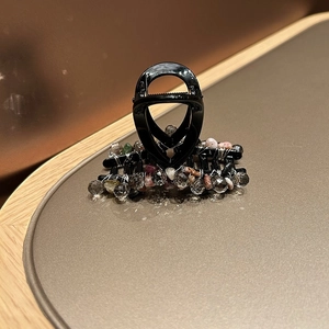 Détail macro d'une pince à cheveux de 13 cm avec cristaux colorés et fil d'argent