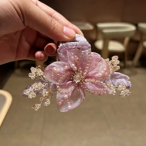 Dettaglio della molletta per capelli a fiore in organza rosa con perle e cristalli