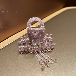 Detail of lavender fabric hair claw clip with iridescent beads and hanging tassel
