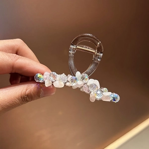 Détail d'une pince à cheveux faite main avec cristaux roses et pierres irisées
