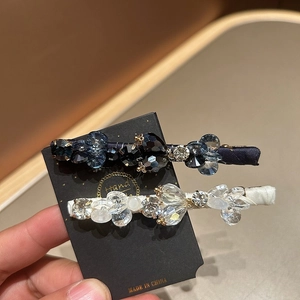 Close-up of sparkling crystal hair clips with dark blue beads and fabric wrapping