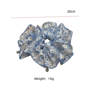 Vue détaillée du chouchou fleuri bleu avec pompon cristal et marquage de taille 20cm