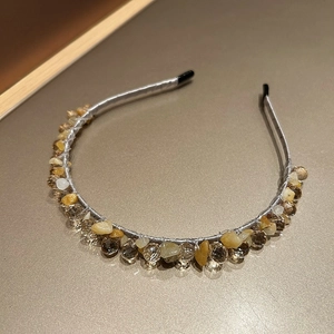 Close-up of handmade headband with golden crystal beads and natural brown stones