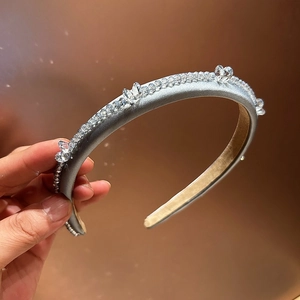 Detailed close-up of light blue satin headband with shimmering crystals and soft velvet lining