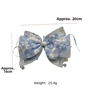 Détail du nœud de cheveux en seersucker bleu à fleurs avec dimensions 20cm x 16cm et gland cristal